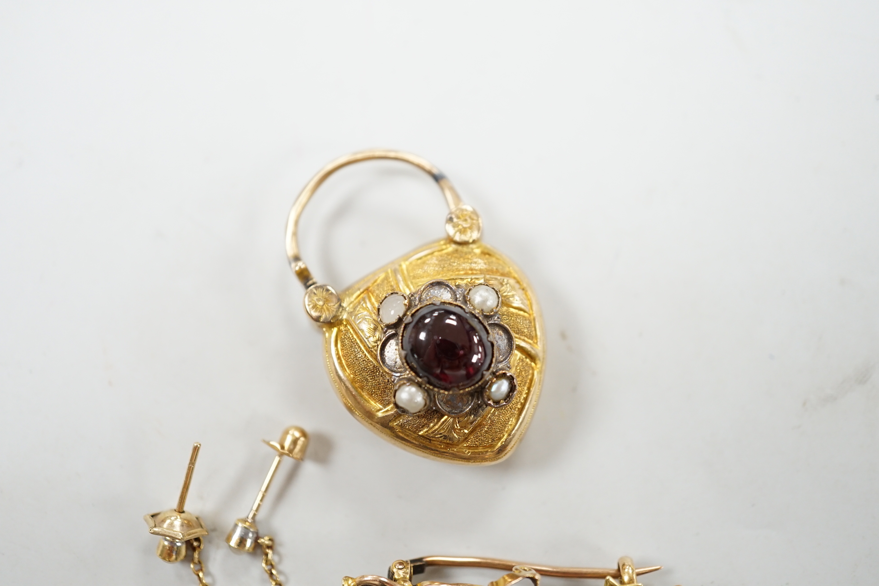 A Victorian yellow metal, garnet and seed pearl set heart shaped locket pendant, 36mm, a pair of Edwardian 15ct and seed pearl cluster set drop earrings and a yellow metal set seed pearl brooch.